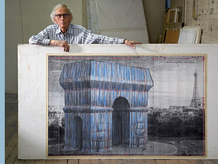 Christo in his New York studio with a preparatory drawing for L'Arc de Triomphe, Wrapped © Wolfgang Volz 2019 / Christo and Jeanne-Claude Foundation
